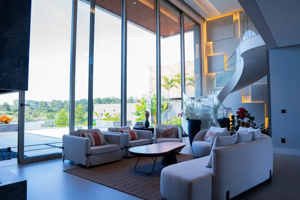 Living com escada escultural e grandes panos de vidro