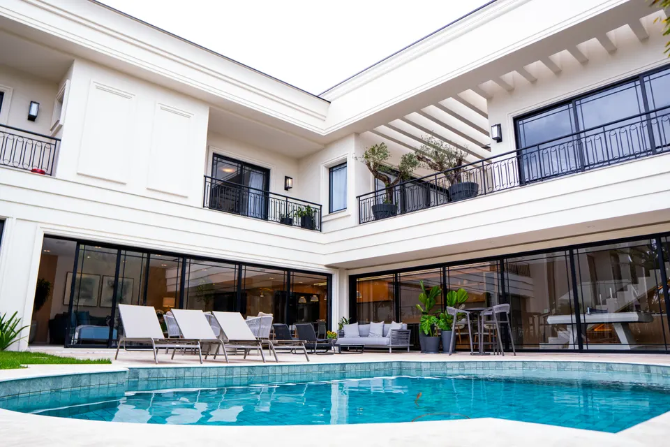 Pátio de residência clássica integrado à piscina